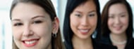 Businesswomen in a row, smiling at camera, Caucasian woman in the front